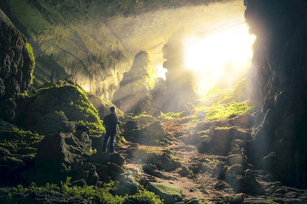 Dramatic limestone formations illuminate the entrance to Bat Cave, a 250-million-year-old geological wonder